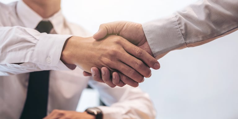 Investor shaking hands with a loan provider because he leveraged his real estate to reduce his unsecured loan payments