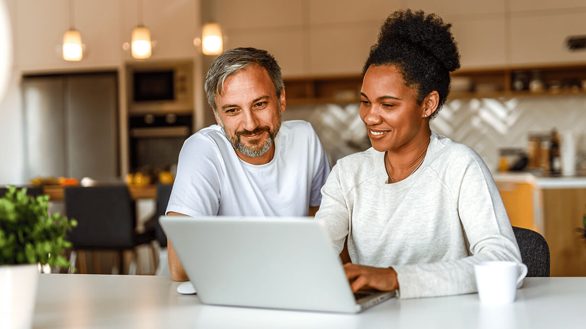 Couple-planing-finances-on-a-laptop-in-their-kitchen