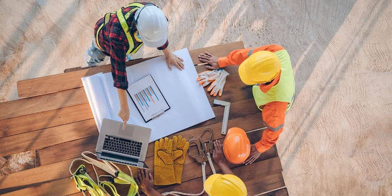 Builders reviewing best practices for using residential construction loans in California at a job site