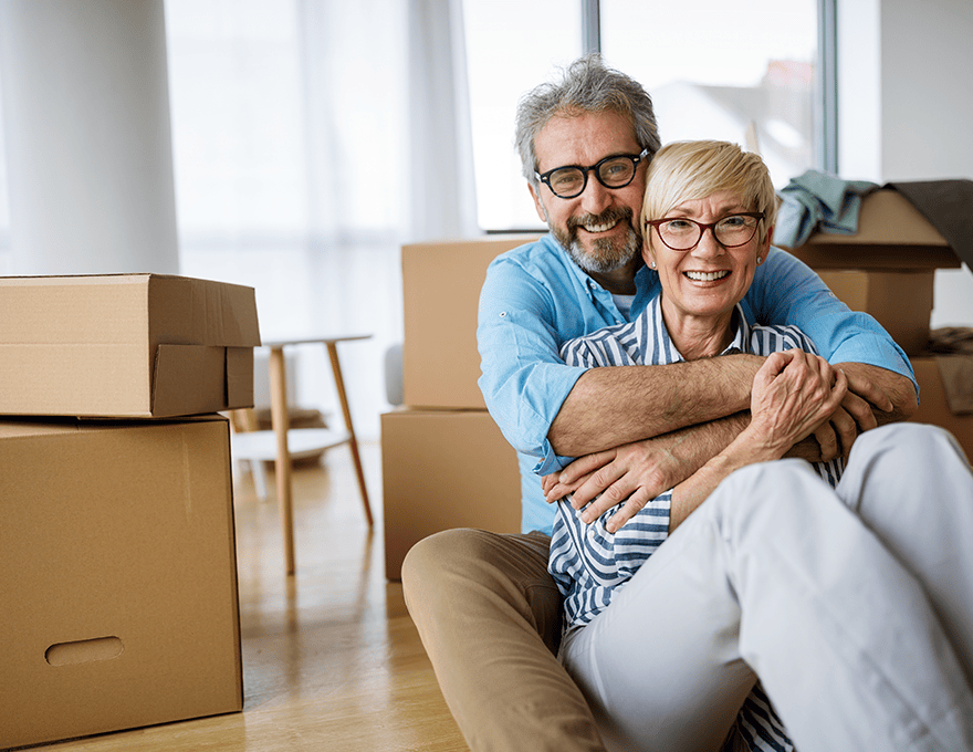 Mature couple hugging while moving into new house