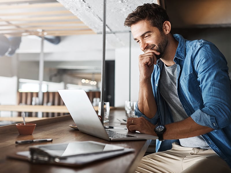 Smiling Man using a Laptop