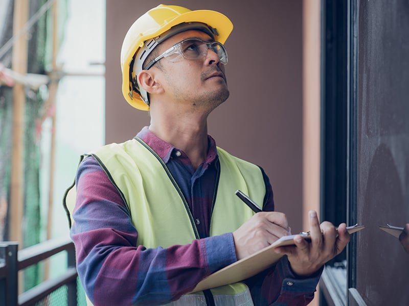 Construction worker inspecting a building