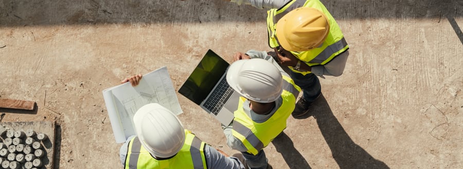 Contratcors using software on a laptop while at a job site