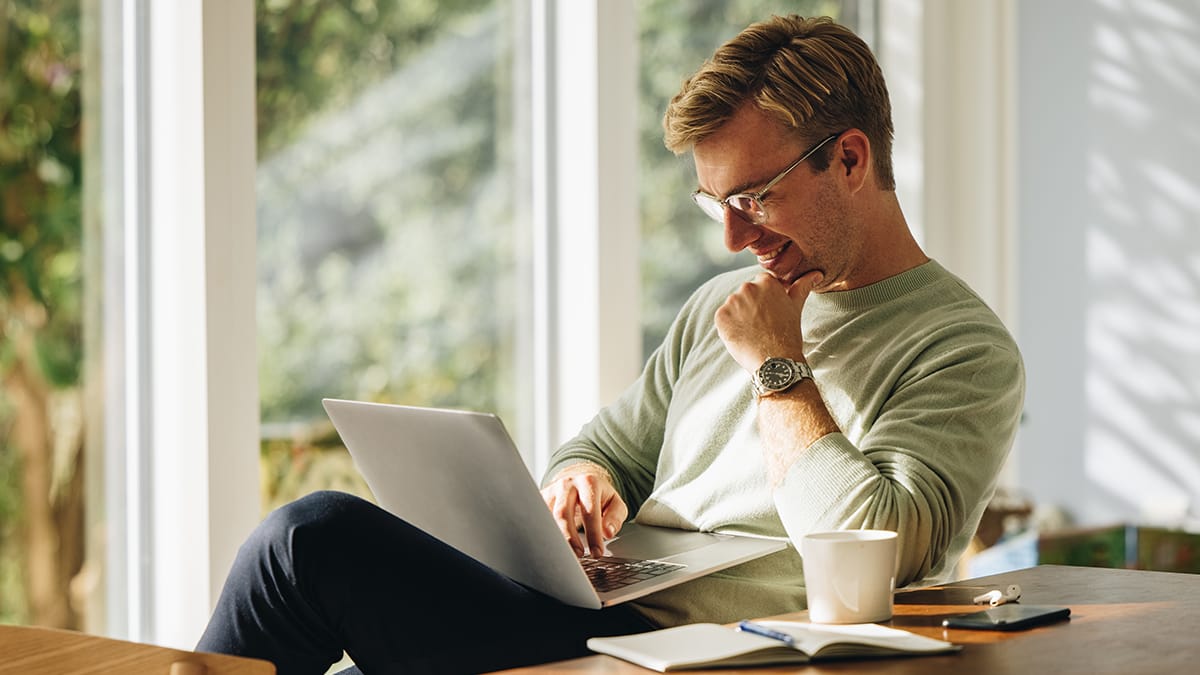 A homeowner using a laptop in his kitchen