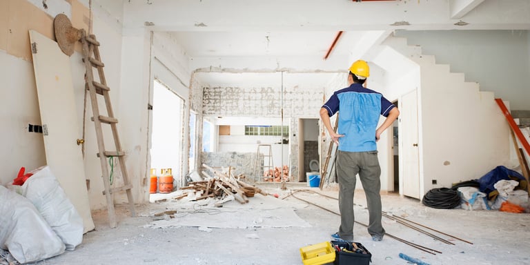 eal estate investor with a hard hat on assessing his fix-and-flip property as it undergoes renovations